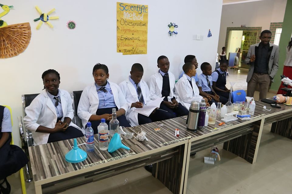 Students in lab coats during a science exhibition